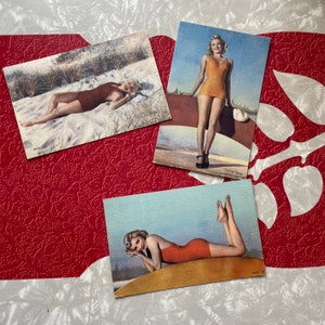May include: Three vintage postcards featuring women in swimsuits. The postcards are in black and white and feature a woman in a swimsuit on a beach. The postcards are in good condition and would make a great addition to any collection.