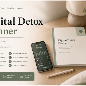 May include: A digital detox planner with a smartphone displaying usage data, a notebook, and a pen. The planner's cover reads "Digital Detox Planner." The image also includes a cup of coffee and decorative items, all on a wooden surface.
