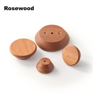 Op de afbeelding: Vier ronde rozenhouten knoppen van verschillende groottes met zichtbare houtnerven. De knoppen hebben gladde, taps toelopende randen en metalen schroefdraadinzetstukken voor montage. De tekst Rosewood staat in de linkerbovenhoek van de afbeelding.