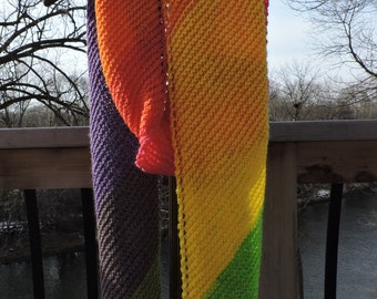 May include: A colorful knitted scarf with stripes of purple, green, yellow, orange, and red.