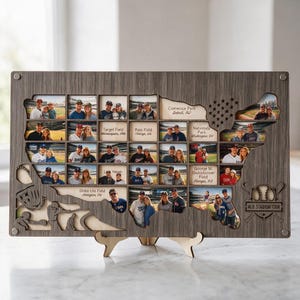 May include: A rectangular wooden display board shaped like the United States map, featuring cutouts for photographs of baseball stadiums. The board includes engraved text for various stadium names and a logo labeled MLB STADIUM TOUR.