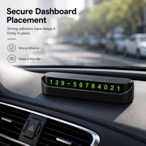 Może przedstawiać: Czarna, prostokątna tabliczka z numerem telefonu parkingowego na deskę rozdzielczą samochodu, z jasnozielonymi cyframi 1 3 9 - 5 6 7 8 4 0 2 1. Urządzenie ma smukłą, niskoprofilową konstrukcję przeznaczoną do umieszczenia na desce rozdzielczej.