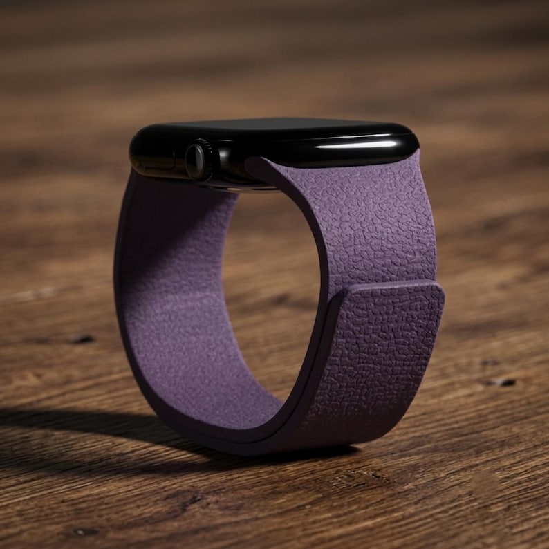May include: A smartwatch with a black rectangular case and a textured purple silicone band. The band features a smooth, matte finish with a distinct pebbled grain pattern on the outer surface, secured by a simple overlapping strap design.