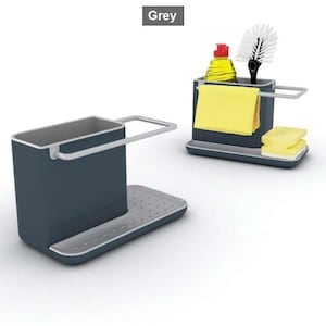 May include: A grey kitchen sink organiser with a rectangular container, a built-in rail for a cloth, and a perforated base tray. One unit is empty, while the other holds a yellow cloth, a yellow sponge, a dish soap bottle, and a brush.