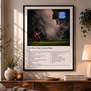 May include: A framed poster with the text "This Music May Contain Hope" and a list of song titles. The artwork features a person in a red dress on a green field, with a dramatic sky backdrop.