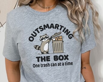 Outsmarting the Box Raccoon T-Shirt | Clever Raccoon Graphic Tee | Eco-Friendly Animal Lover Shirt | Funny Wildlife Friend Gift Tee