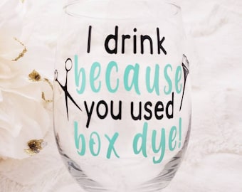 Puede incluir: Una copa de vino de vidrio transparente con un diseño negro y turquesa que dice "¡Bebo porque usaste tinte de caja!"