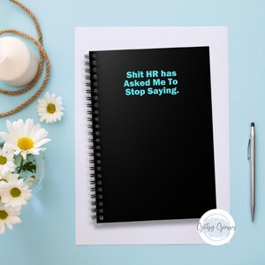 May include: Black spiral bound notebook with the text "Shit HR has Asked Me To Stop Saying." in blue text.
