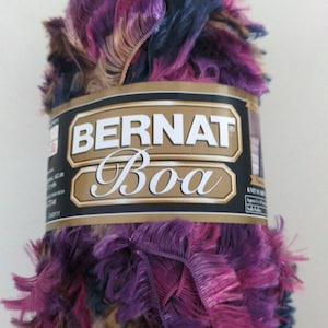 May include: A skein of Bernat Boa yarn in a multi-colored mix of purple, pink, blue, and brown. The yarn is a fluffy, fuzzy texture.