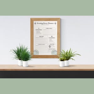 Peut inclure: Un document Evening Reset Planner encadré dans un cadre en bois clair. Le planificateur comprend des sections pour Morning Routine, Selfcare Activity, Relax Time, Evening Routine, Tomorrow's Focus et Screen Time, avec du texte noir sur fond blanc.