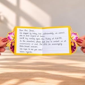 May include: A small, rectangular, yellow-bordered note card featuring a handwritten message addressed to Mrs. Jones. The card is decorated with vibrant purple and yellow floral accents on both sides and contains text about a missed visit.