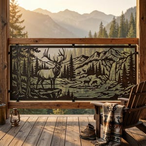 May include: A dark metal decorative railing panel featuring a laser-cut landscape scene with a large elk in the foreground, smaller deer, pine trees, mountains, and a waterfall. The panel is mounted within a wooden frame on a deck.