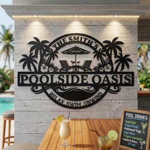 Könnte beinhalten: Ein schwarzes Metall-Wandschild mit einem kreisförmigen Design aus Palmen, zwei Liegestühlen, einem Sonnenschirm und einem kleinen Tisch. Der Text lautet THE SMITH'S, POOLSIDE OASIS und RELAX, SWIM, UNWIND. Das Schild ist an einer hellen Holzwand befestigt.