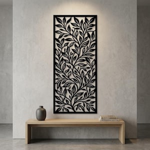 May include: A rectangular black wall panel featuring a laser-cut design of intricate, overlapping leaves and branches. The panel is mounted vertically on a wall, displaying a dense, continuous botanical pattern that fills the entire frame.