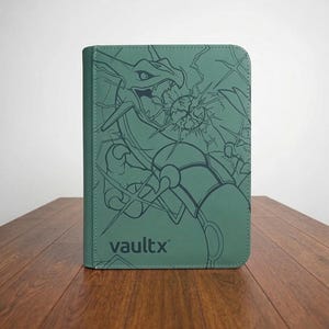 Può includere: Un raccoglitore per carte verde salvia con un'illustrazione a linee verde scuro di una creatura simile a un drago che emette energia. La copertina presenta il testo vaultx in un carattere sans-serif, con bordi cuciti e angoli arrotondati.