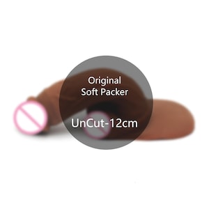 Puede incluir: Un packer suave de color marrón con forma curva. El texto en la imagen dice Original Soft Packer UnCut-12cm. El objeto tiene una apariencia suave y flexible y se presenta en una orientación horizontal sobre un fondo liso.