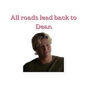 Peut inclure: Un autocollant découpé représentant le portrait d'une personne blonde à l'expression neutre portant un pull vert olive foncé. Au-dessus du portrait, le texte All roads lead back to Dean est écrit en rose avec un contour blanc.