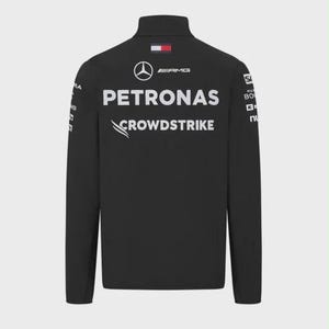 May include: A black long-sleeve jacket featuring a high collar and white printed logos. The back displays the Mercedes-Benz star, AMG, PETRONAS, and CROWDSTRIKE branding, along with a small rectangular Tommy Hilfiger flag logo at the neckline.