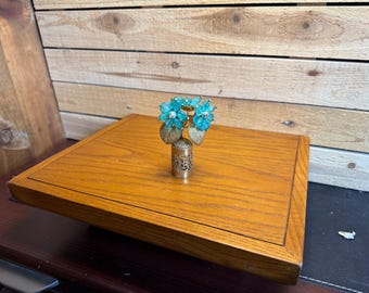 Tapón de frasco de perfume vintage azul con estampado floral y adorno de joya para tocador.