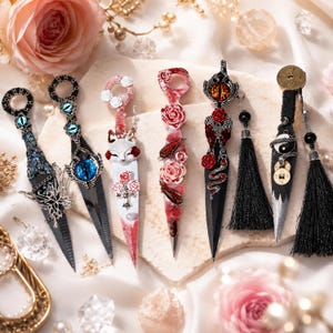 May include: Six decorative kunai daggers featuring distinct designs including blue dragon eyes, a white fox, red roses, a serpent, and yin-yang symbols. Each dagger has a ring pommel and intricate metalwork, with some featuring black tassels.