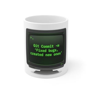 Op de afbeelding: Witte keramische mok met een retro computerscherm ontwerp. Het scherm toont de tekst "Git Commit -m 'Fixed bugs, created new ones'" in groen op een zwarte achtergrond. De mok heeft een eenvoudig, strak ontwerp.