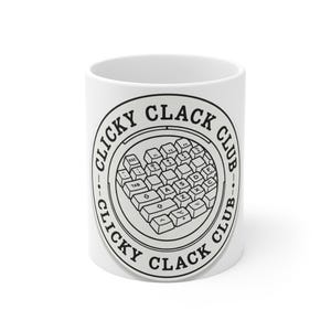 May include: White ceramic mug with a black and white design. The design features a keyboard layout in the center, surrounded by the words "CLICKY CLACK CLUB" in a circular pattern. A fun gift for computer enthusiasts.