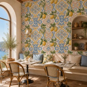 May include: A room featuring wallpaper with a yellow lemon and blue floral pattern, a built-in arched wooden shelf, two square tables with light-coloured tops, and four woven rattan chairs with blue accents, set against a view of the ocean.