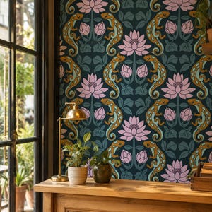 May include: Wallpaper featuring a repeating pattern of orange and teal lizards interspersed with pink lotus flowers and green leaves on a dark charcoal background. The design is symmetrical, showcasing stylized reptiles and floral elements.