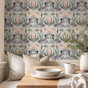 May include: Wallpaper featuring a repeating pattern of ducks, bulrushes, and lotus flowers in muted tones of blue, green, and peach on a light grey background. The design includes stylised suns and lily pads arranged in a symmetrical, decorative layout.