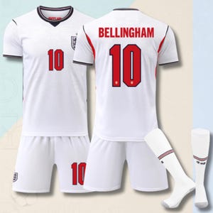 Può includere: Un completo da calcio dell'Inghilterra bianco composto da maglia e pantaloncini, con il numero 10 in rosso e bordi neri. Sul retro della maglia è presente il nome BELLINGHAM in rosso. Il set include un paio di calzettoni bianchi con finiture.