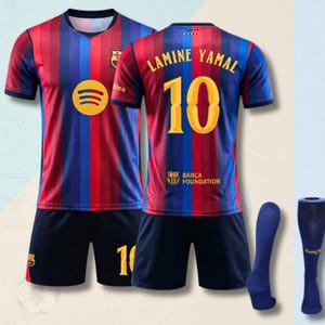 May include: A soccer kit featuring a short-sleeved jersey with vertical red and blue stripes, a yellow Spotify logo, and the FC Barcelona crest. The back displays the name LAMINE YAMAL, the number 10, and the Barça Foundation logo. Includes dark blue shorts and socks.