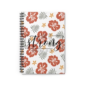 May include: A spiral-bound notebook with a white cover featuring a repeating pattern of rust-colored hibiscus flowers, gray palm leaves, and small yellow flowers. The text "SHE IS strong" and "PROVERBS 31:25" is printed in black in the center.