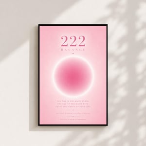 以下が含まれることがあります： ピンクの背景に数字の222、BALANCEという単語、そして輝くピンクの円形オーラが描かれた額入りアートプリント。テキストには「YOU ARE IN THE RIGHT PLACE, YOU ARE ON THE RIGHT PATH, TRUST THE TIMING OF YOUR LIFE」と記されています。