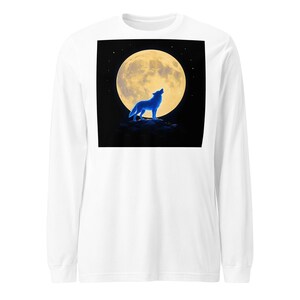 May include: A white long-sleeve shirt featuring a centered square graphic of a bright yellow full moon against a black night sky. A glowing blue wolf stands on a dark rocky outcrop in the foreground, positioned in front of the moon.