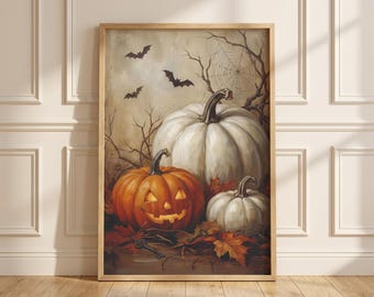 May include: A framed wall art print featuring a large white pumpkin, a smaller white pumpkin, and a glowing orange jack-o'-lantern resting on fallen autumn leaves. The scene includes bare tree branches, a spider web, and three flying bats.
