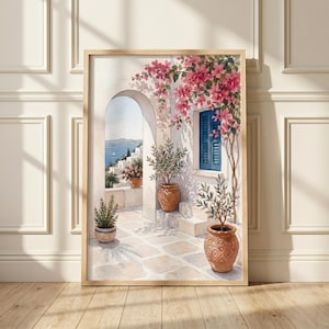 Op de afbeelding: Een ingelijste wandkunstprint met een mediterrane scène met een stenen boog, blauwe luiken en terracotta potten met groene planten. Levendige roze bougainvillea-bloemen draperen over de boog met uitzicht op de zee.