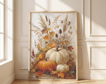 May include: A rectangular wall art print in a light wood frame featuring a watercolor illustration of three pumpkins in shades of orange and cream, surrounded by dried autumn foliage, tall grasses, and brown seed pods on a light background.