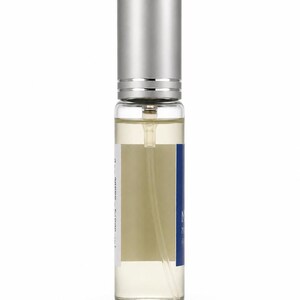 Manifesting 15ml discovery eau de parfum translucent glass front view with dark cobalt blue label — Maison Voyageur Mediterranean artisanal parfumerie Madrid unisex