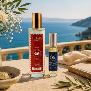 Peut inclure: Un flacon de parfum en verre transparent avec un bouchon doré et une étiquette rouge portant l'inscription CELESTE RELEASE, à côté d'un flacon à bille plus petit avec un bouchon argenté et une étiquette bleue marquée MANIFESTING, par Maison Voyageur.