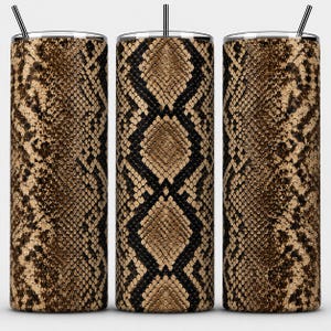 May include: Three cylindrical tumblers featuring a repeating brown and black snakeskin pattern. Each tumbler has a flat lid and a thin, straight metal straw extending from the top. The design displays a detailed, textured scale print.