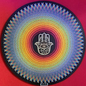 Könnte beinhalten: Kreisförmige Wandkunst mit einem Regenbogen-Schnur-Design, das von einem zentralen schwarzen Kreis ausgeht. Der schwarze Kreis enthält ein weißes Hamsa-Hand-Symbol. Das Kunstwerk befindet sich auf einem schwarzen Hintergrund mit rotem Rand.