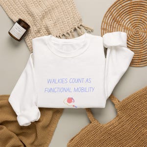 Sudadera con estampado de huellas de perro y la frase "Pasear cuenta como movilidad funcional" (humor sobre pasear mascotas) imagen 1