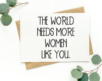 May include: A white card with black text that reads "The world needs more women like you."