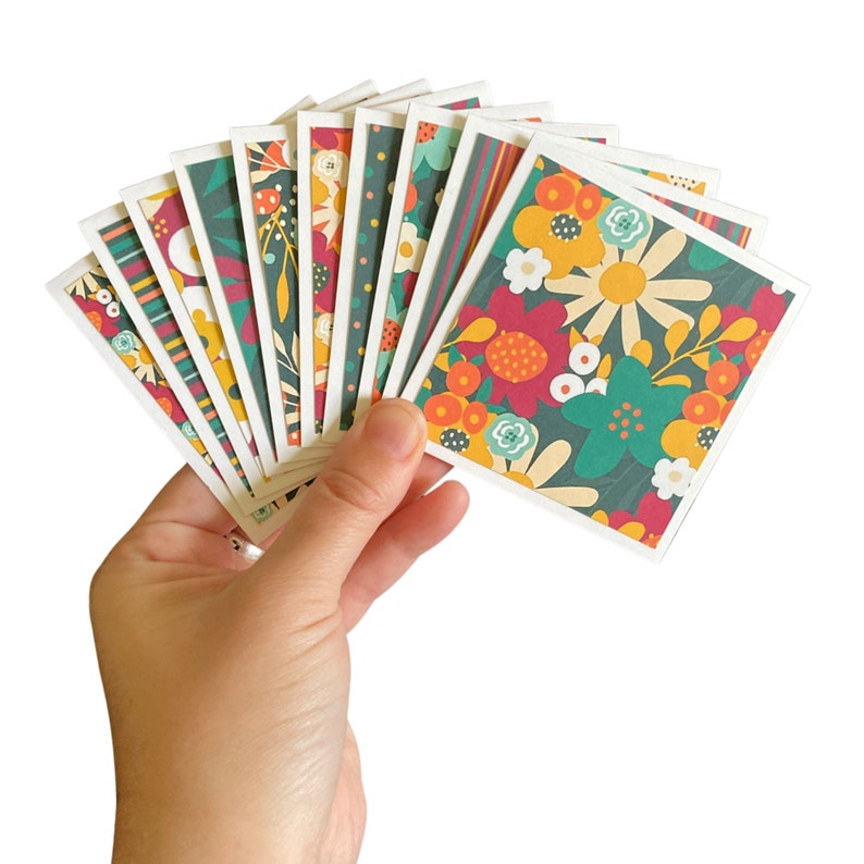 May include: A set of 10 blank greeting cards with a variety of floral patterns in shades of green, red, yellow, and orange. The cards are all different designs and feature a variety of flowers.