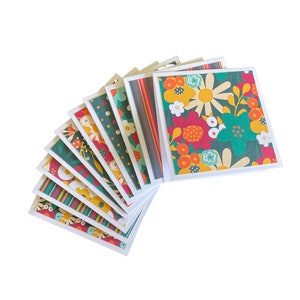 May include: A set of ten blank greeting cards with colorful floral patterns. The cards feature a variety of flowers in shades of red, orange, yellow, green, and blue. The cards are perfect for sending a special message to someone you care about.