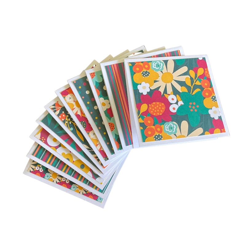 May include: A set of ten blank greeting cards with colorful floral patterns. The cards feature a variety of flowers in shades of red, orange, yellow, green, and blue. The cards are perfect for sending a special message to someone you care about.
