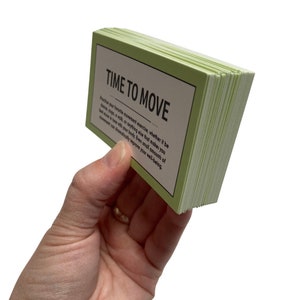 May include: A stack of green cards with the text "TIME TO MOVE" and a message about the benefits of movement. The cards are held in a hand.
