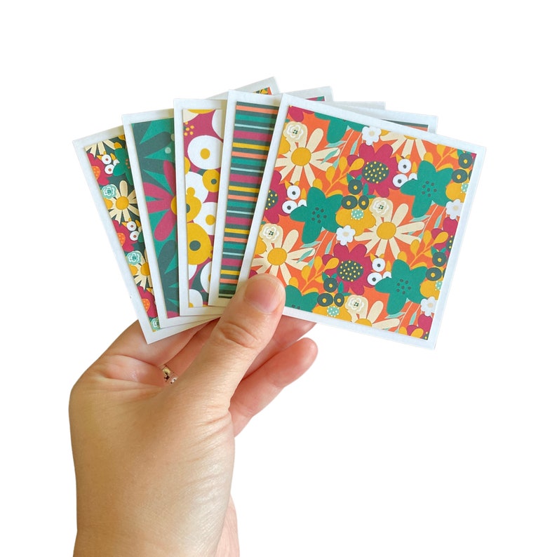 May include: A set of six colorful cards with a floral pattern. The cards are green, red, yellow, and white. The cards are perfect for scrapbooking, card making, or other craft projects.
