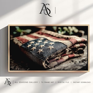 May include: A framed print of a vintage American flag, featuring red and white stripes and a blue field with embroidered stars. The flag appears aged and worn, with a rustic aesthetic. The frame is gold-toned, and the print is set against a neutral background.
