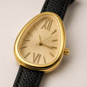 May include: A wristwatch with a gold-toned, teardrop-shaped case and a textured gold sunburst dial. The dial features Roman numerals at the twelve and six o'clock positions, simple gold indices for other hours, and a black textured leather strap.